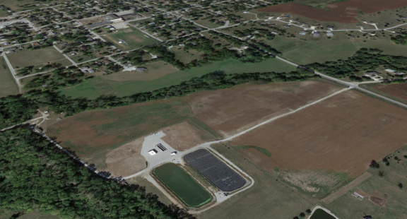 Aerial view of municipal water treatment plant in Maxwell, Iowa consisting of two lagoons and service buildings outside of city limits in a rural agricultural community